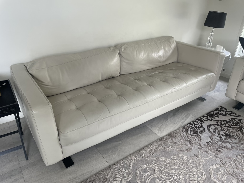 Light leather three-seat lounge before the owner-curated restoration sequence