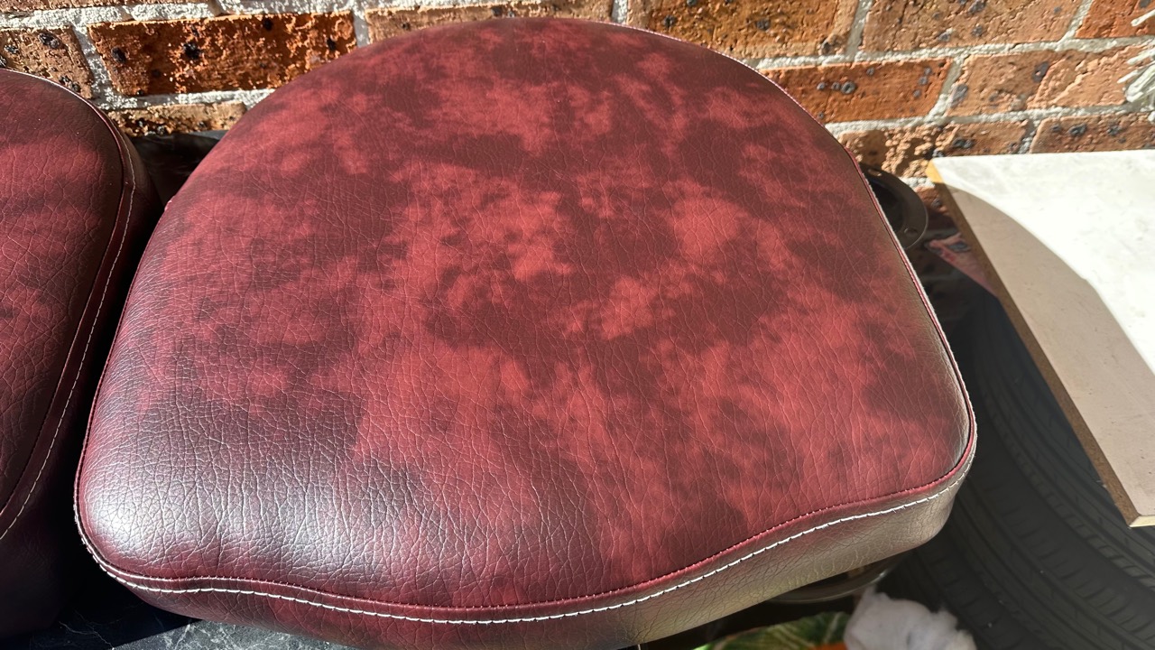 Burgundy leather seat cushion with mottled surface wear